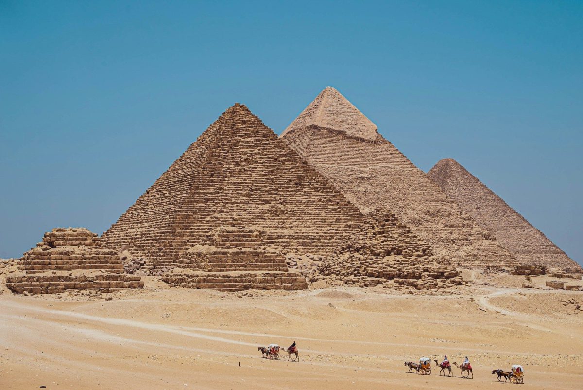 a group of people riding horses next to the pyramids of giza