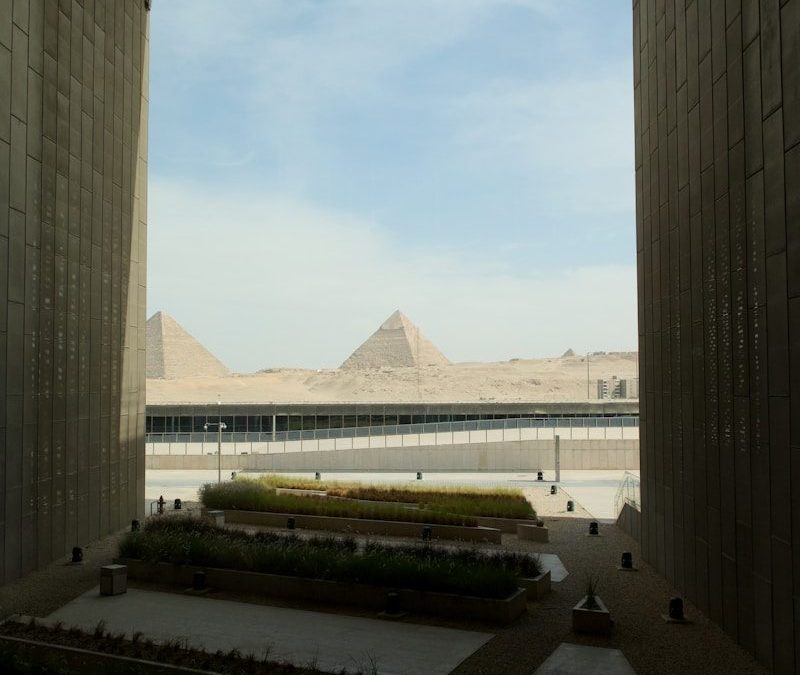 The great pyramids of giza seen through a modern archway.