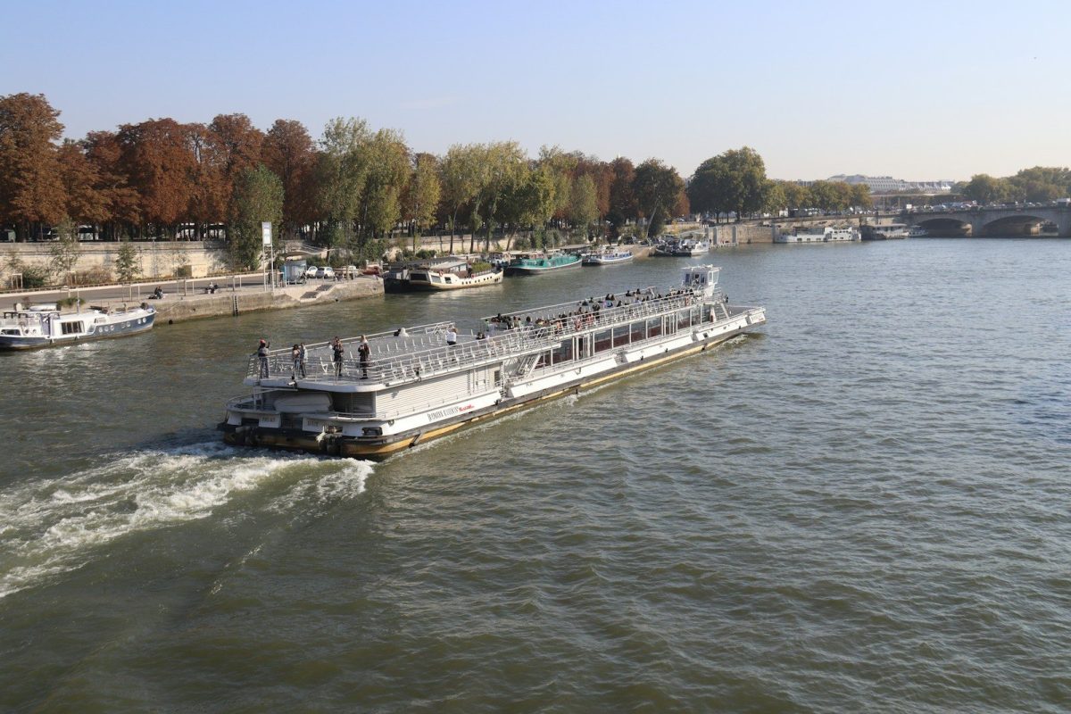 A large boat travels down a wide river.