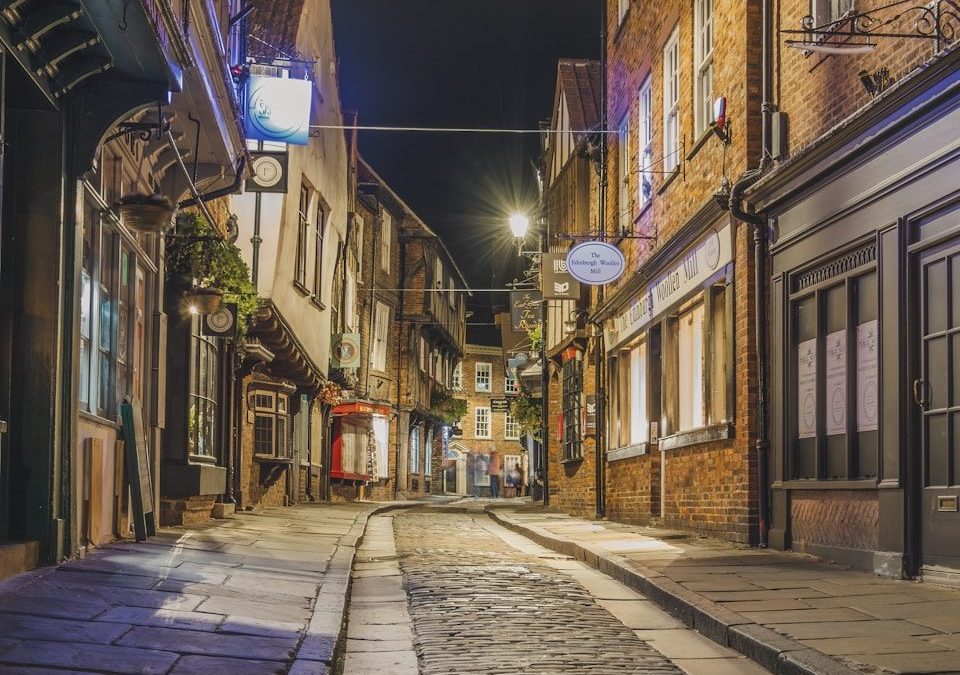 8 Beautiful Streets Around the World to Walk at Least Once 3 a cobblestone street at night with a clock on the building