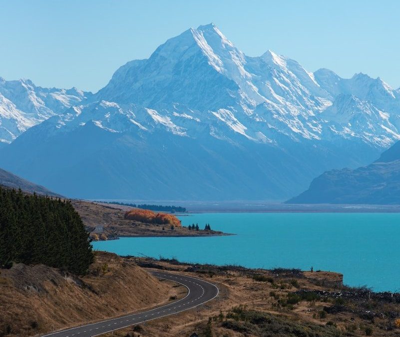 snow covered mountain near body of water during daytime