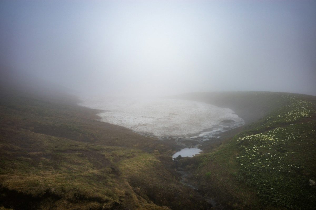 Misty mountain landscape with remnants of snow.