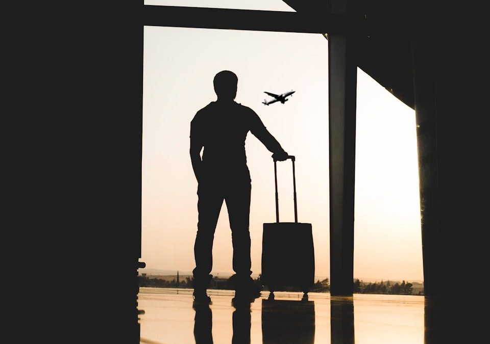 silhouette of man holding luggage inside airport