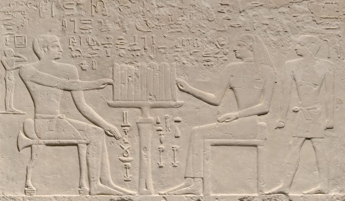 Ancient egyptian relief carving of seated figures and hieroglyphs