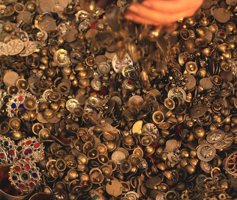 Hands shower glittering gold coins and jewels.