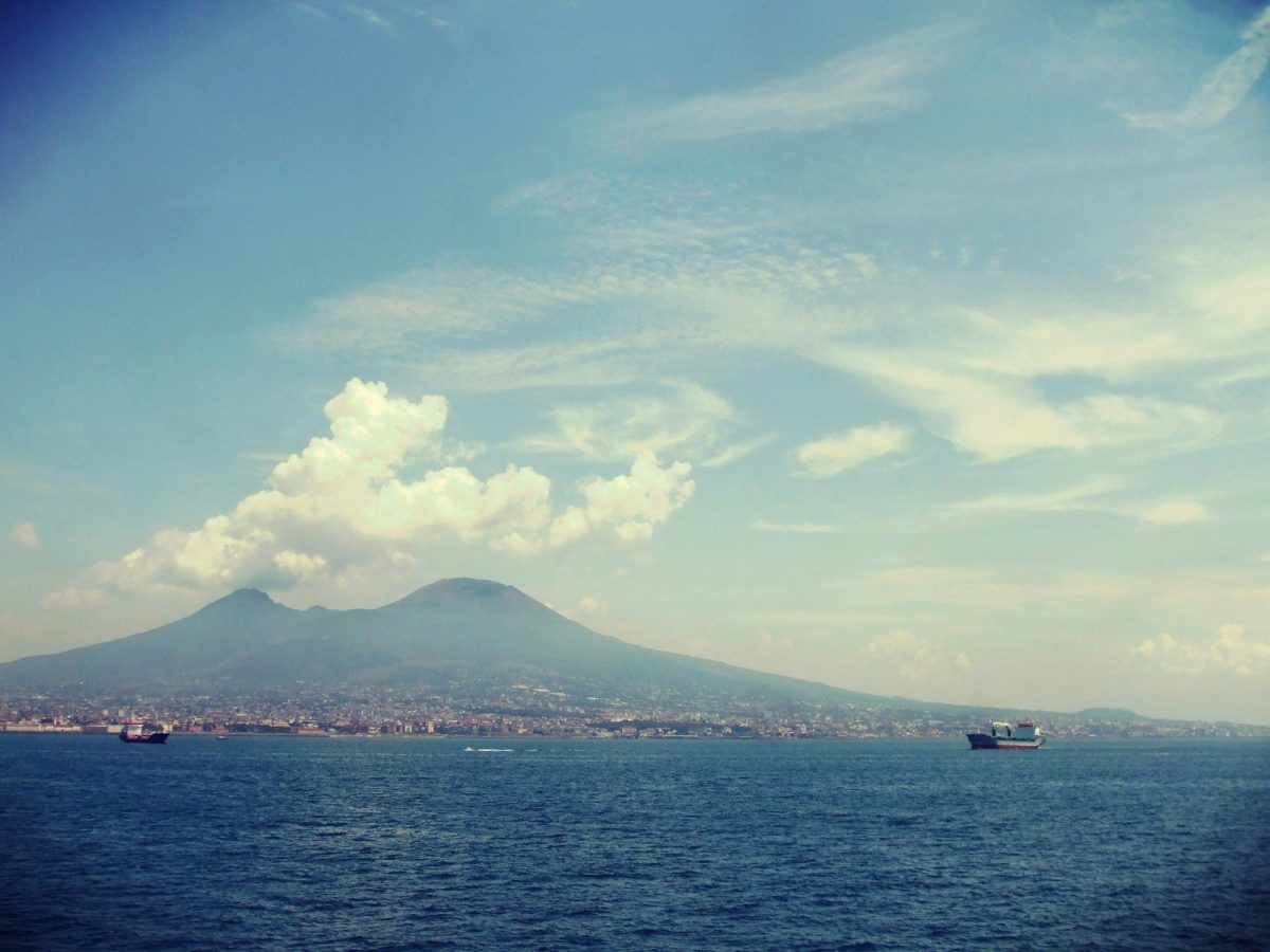 body of water near mountain under blue sky during daytime