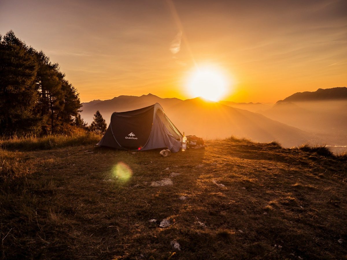 8 Ways to Stay Warm and Comfortable While Traveling in the Wilderness 7 dome tent on mountain top with sun as background photo