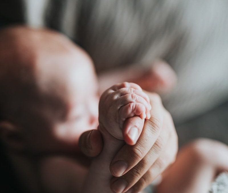 person holding babys feet