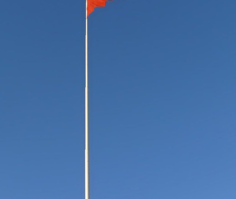a flag is flying high in the blue sky