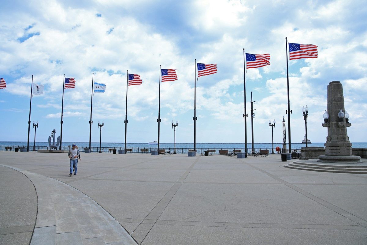 8 Reasons Some European Travelers Are Rethinking U.S. Trips 3 a man walking down a sidewalk next to a bunch of american flags