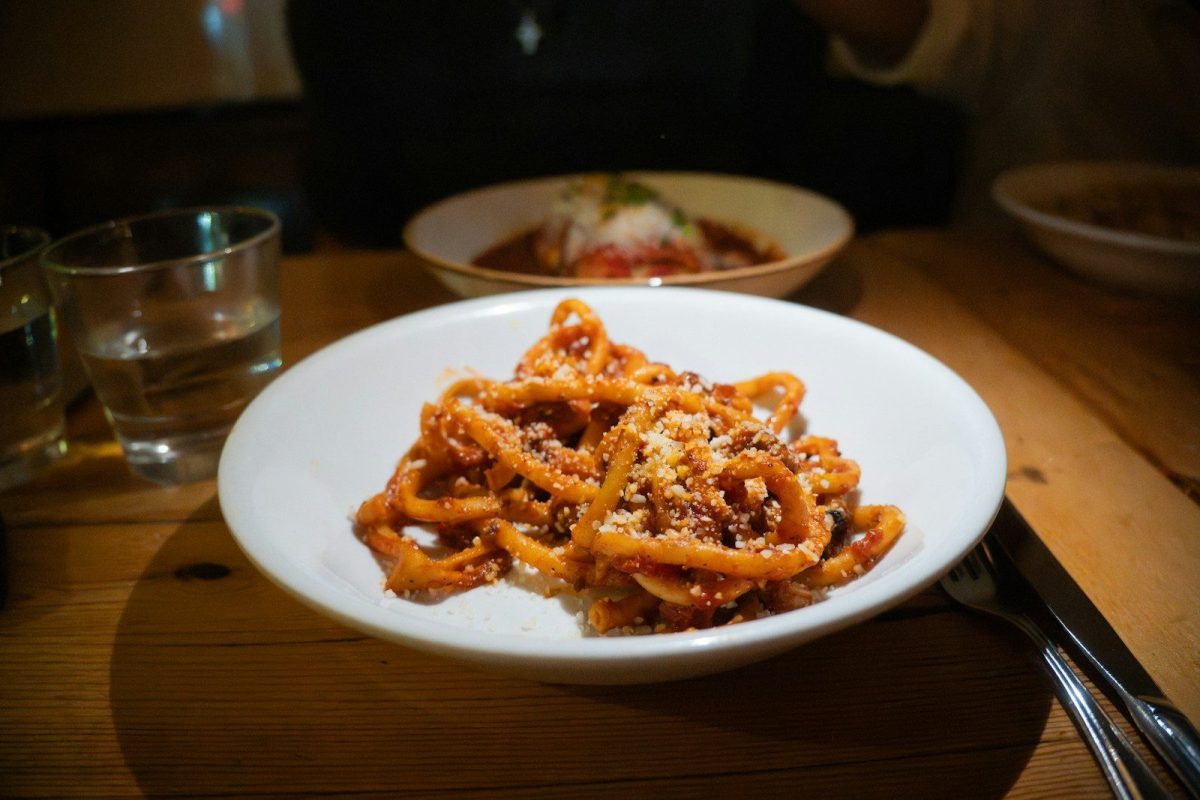 A plate of pasta with sauce and toppings.