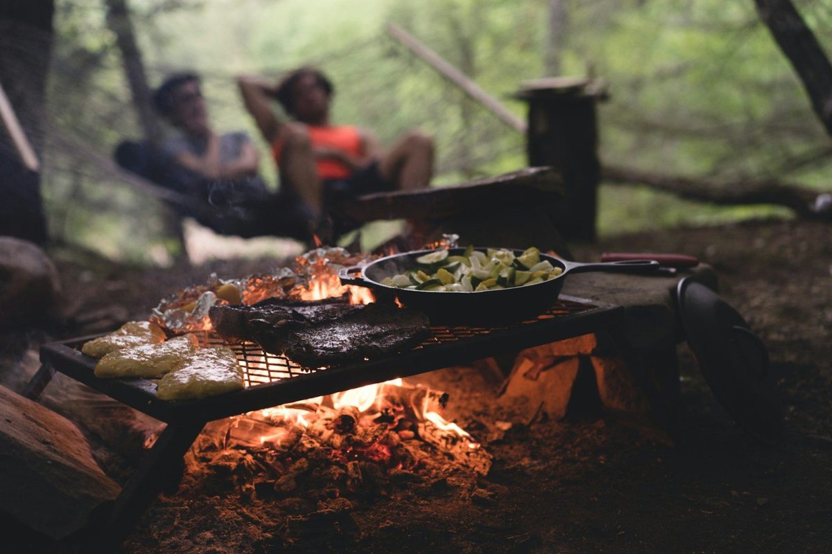8 Ways to Stay Warm and Comfortable While Traveling in the Wilderness 3 selective focus photo of skillet and meat on top of grill with fire