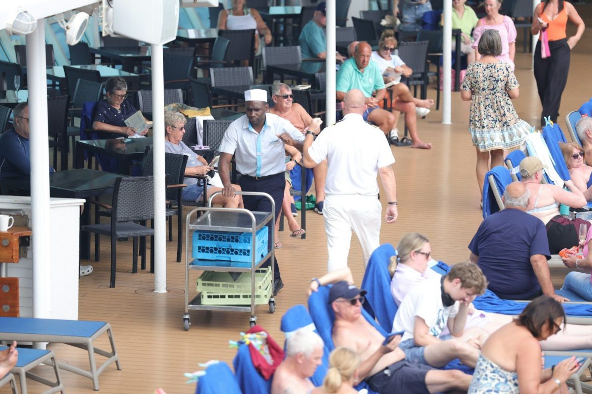 People relaxing and staff working on a cruise ship deck.