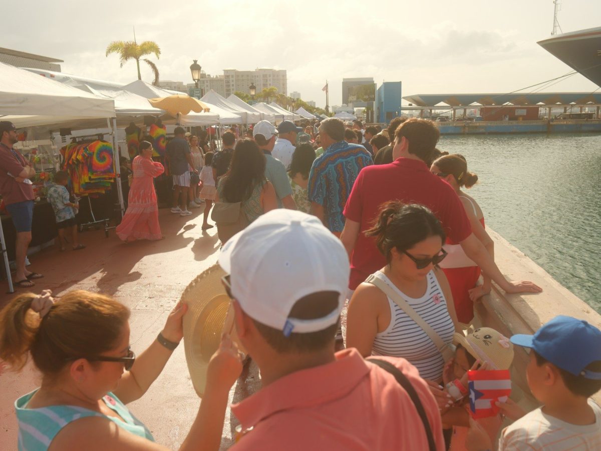 People browsing stalls at an outdoor market by the water