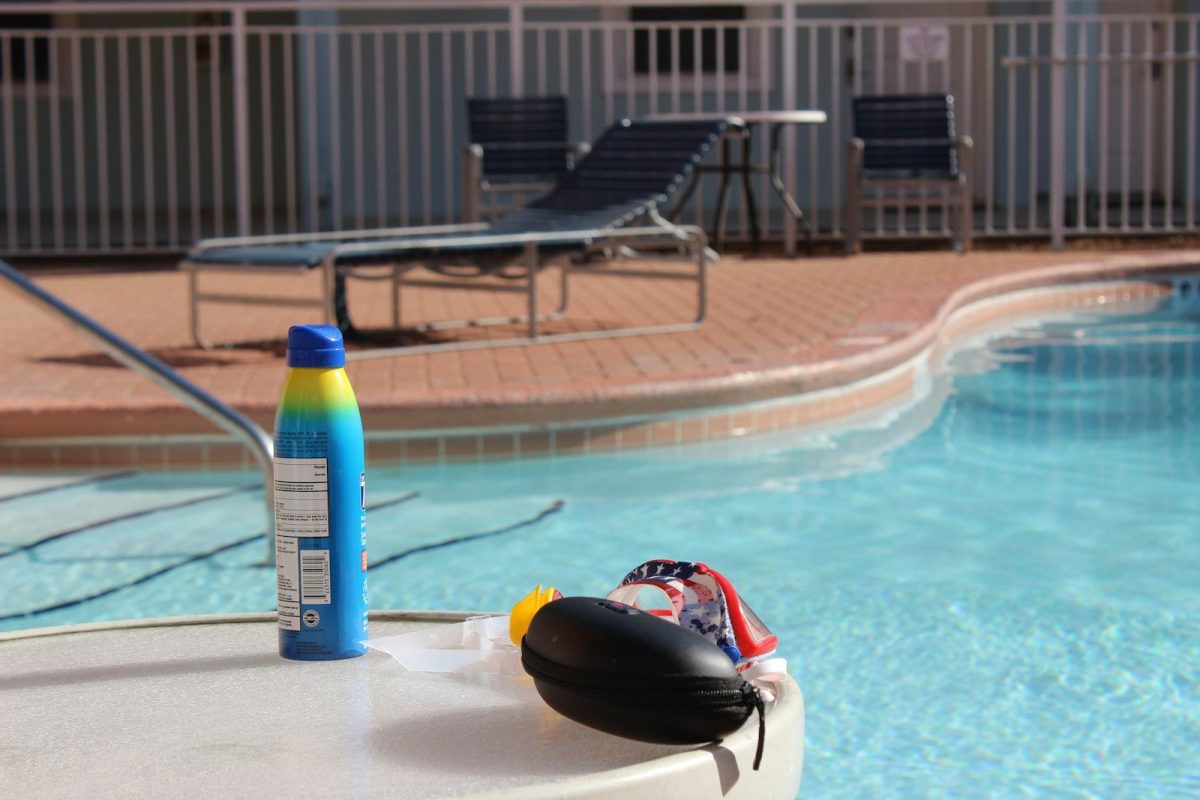 a bottle of sunscreen next to a swimming pool