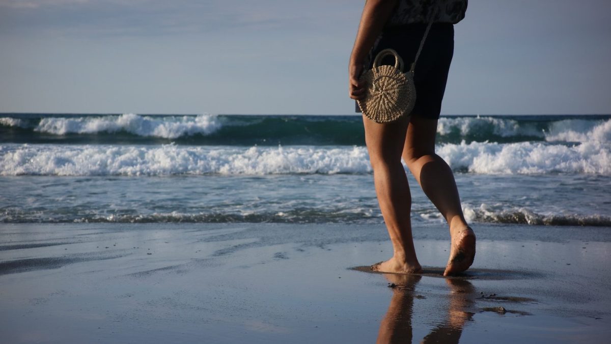 woman in black bikini standing on beach during daytime