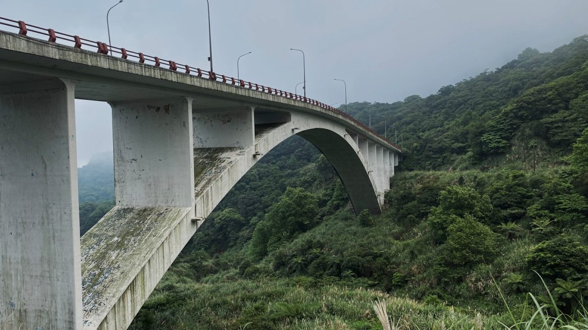 a large bridge over a lush green hillside