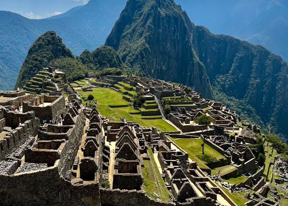 an old city with mountains in the background with Machu Picchu in the background