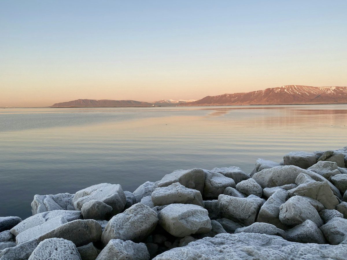 gray rocks near body of water during sunset