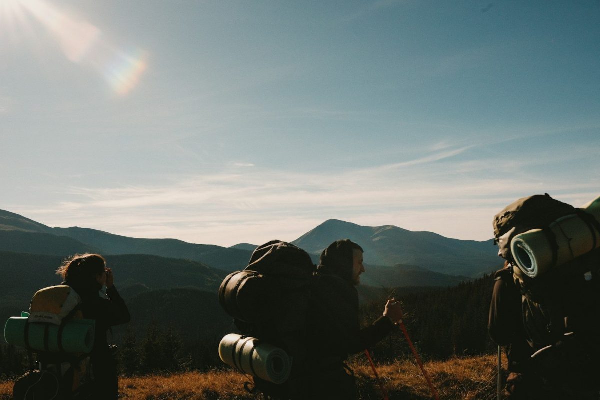 A group of people with backpacks standing in a field