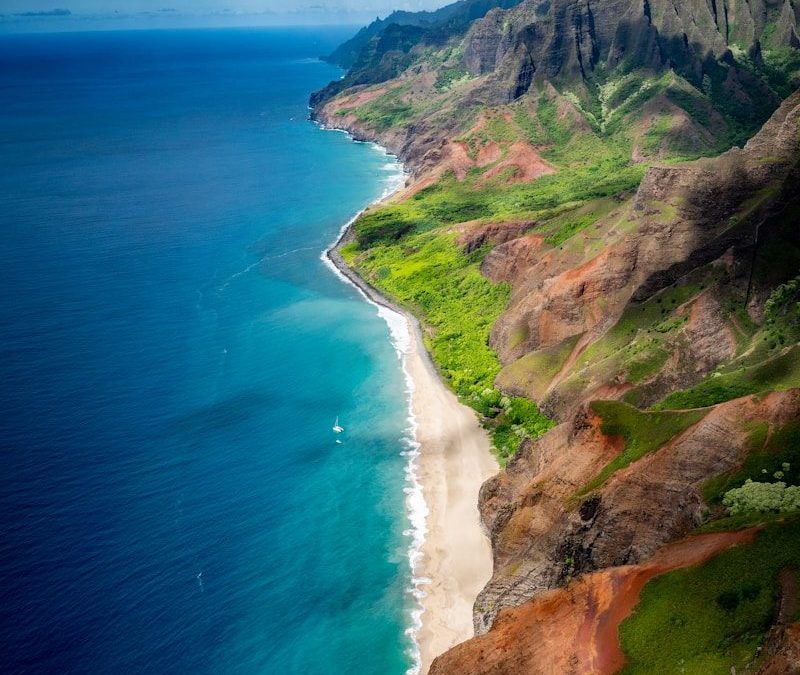 aerial view of green and brown mountain beside blue sea during daytime