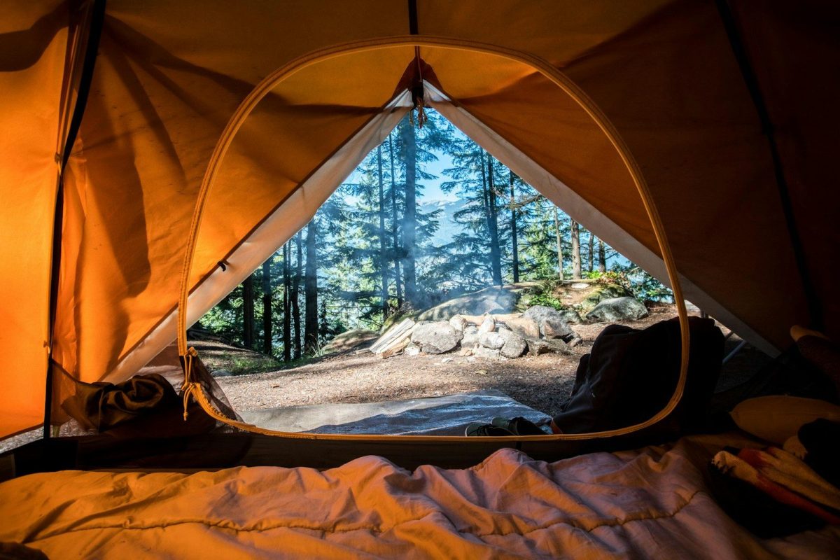 8 Ways to Stay Warm and Comfortable While Traveling in the Wilderness 2 orange camping tent near green trees