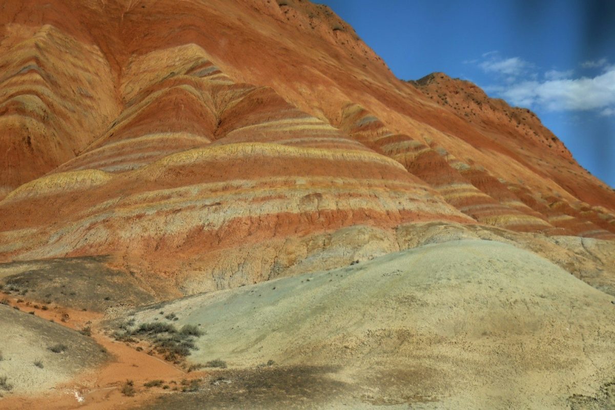 Colorful striped hills under a blue sky