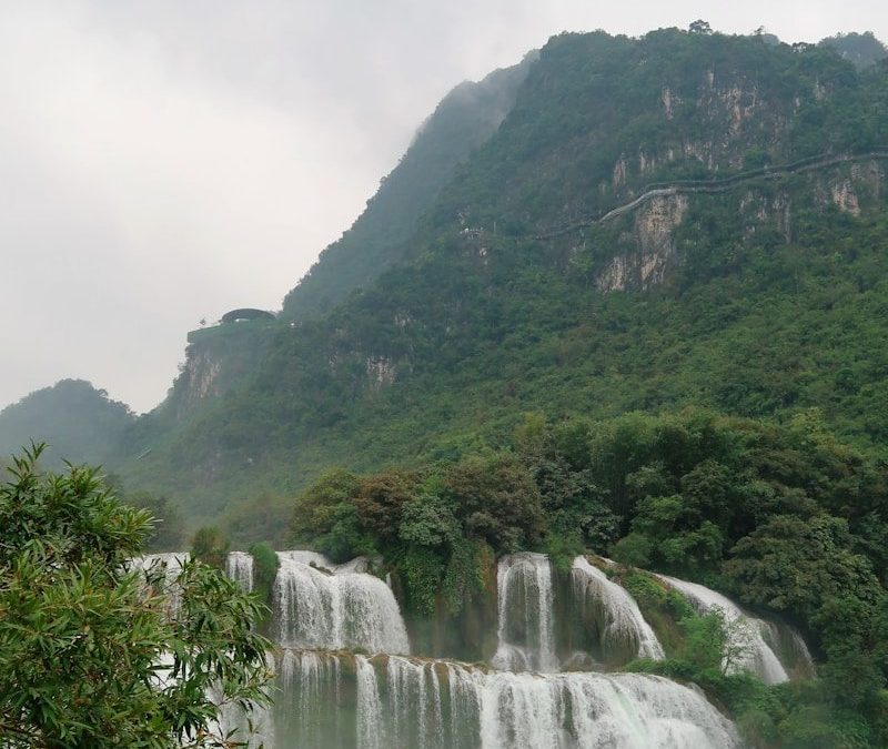 a large waterfall in the middle of a body of water