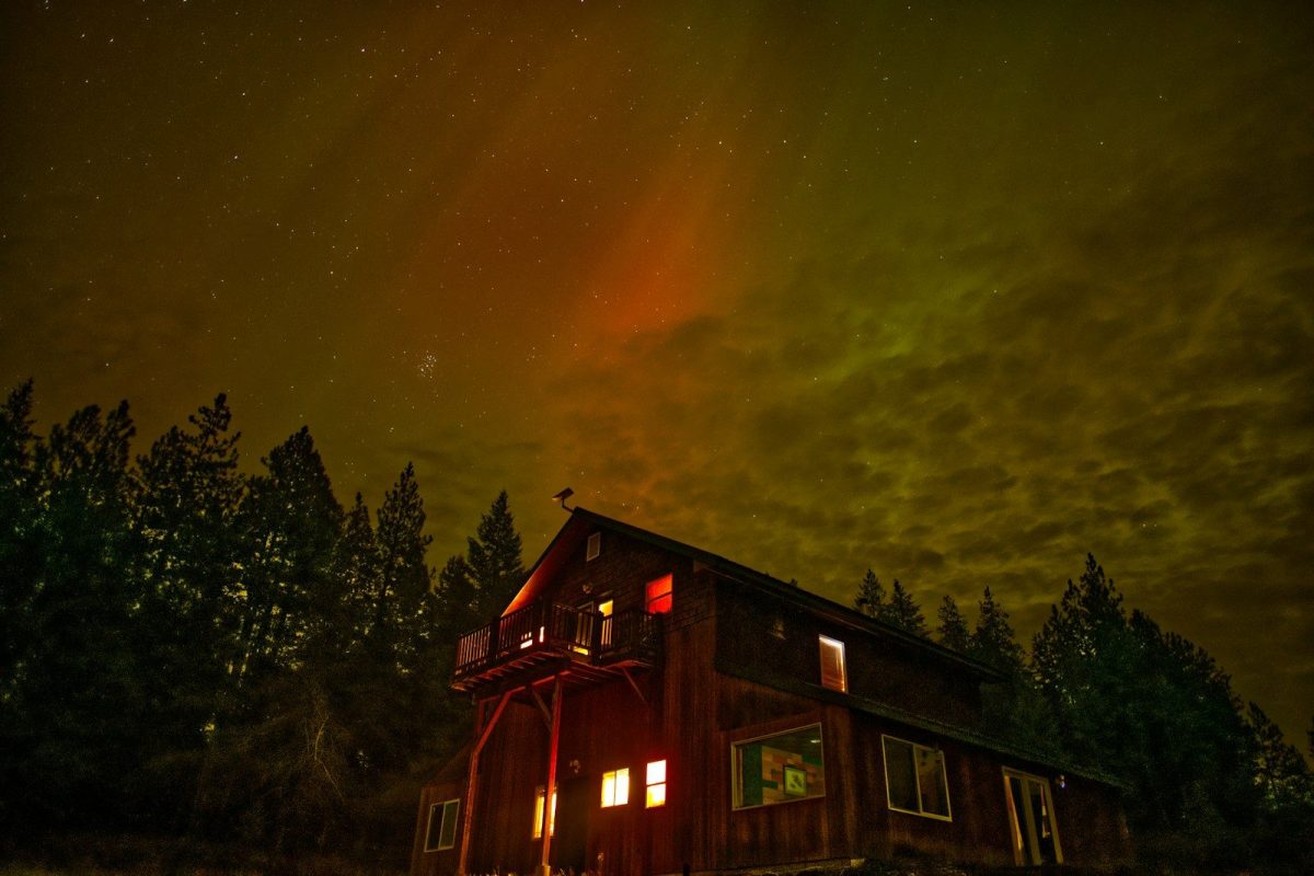 Wooden cabin under the aurora borealis at night