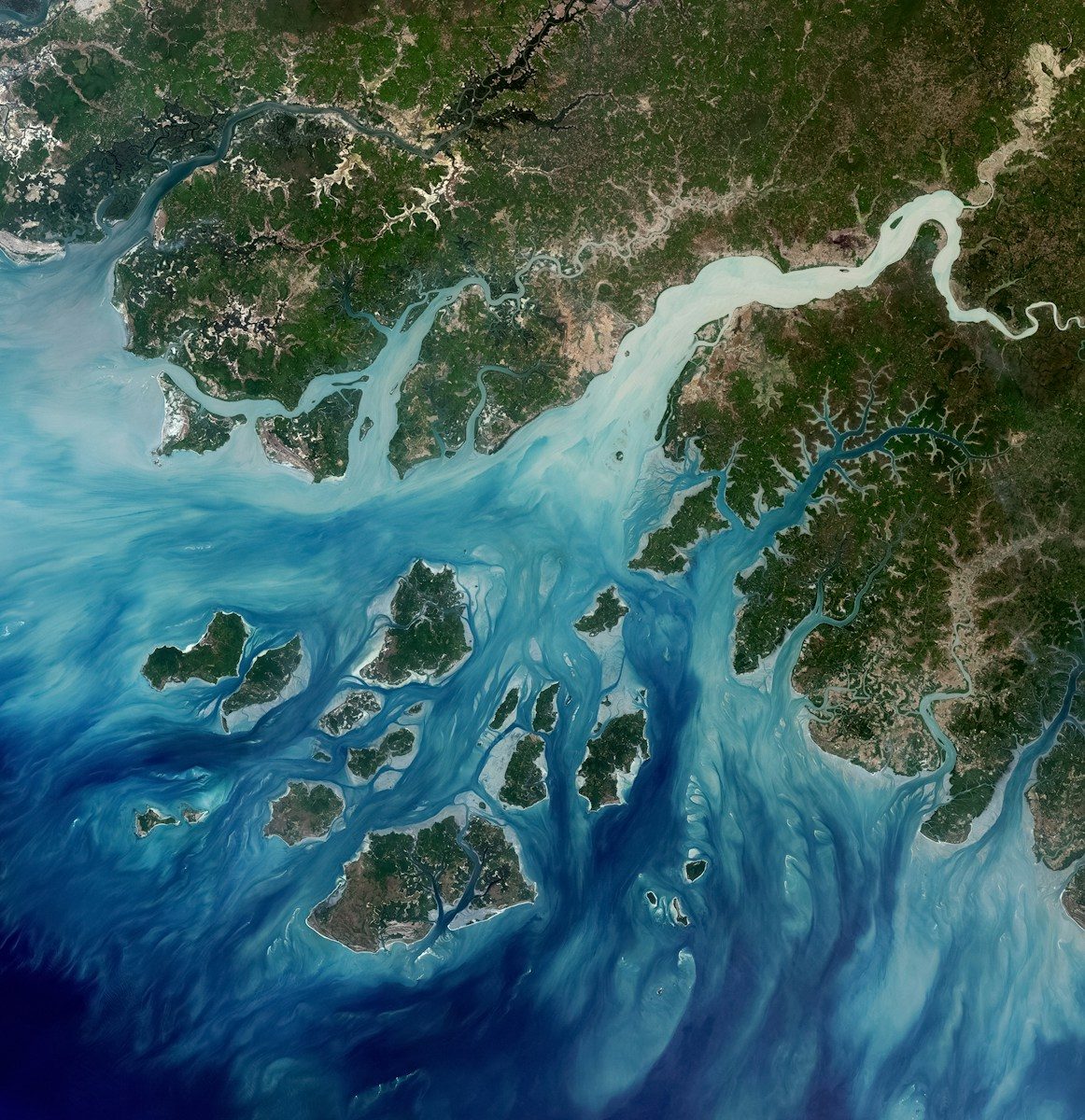 Satellite view of islands in turquoise water with river delta