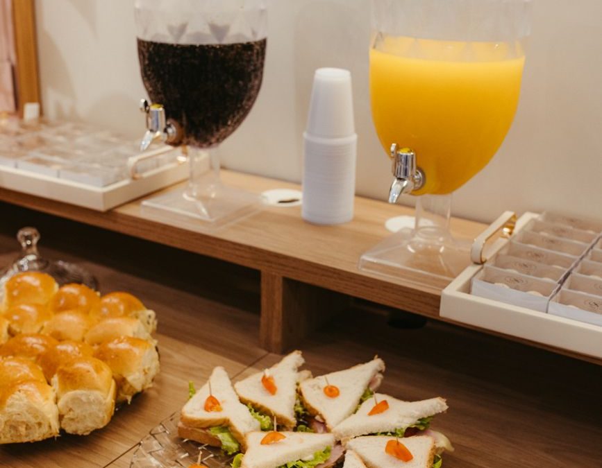 5 Hotel Breakfast Rules Families Should Check Before Leaving the Room 1 Appetizing breakfast buffet setup with drinks and sandwiches ready to serve.