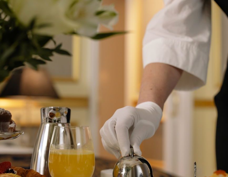 5 Hotel Breakfast Rules Families Should Check Before Leaving the Room 2 Deluxe room service breakfast arrangement with pastries, juice, and elegant table setting in a luxury hotel room.