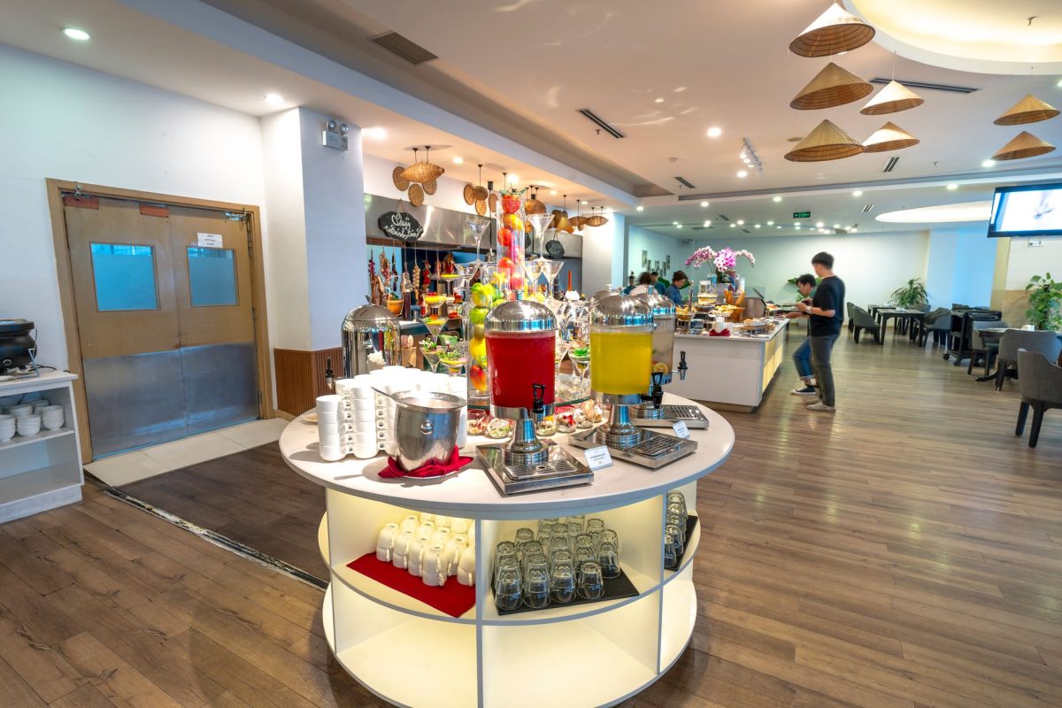 5 Hotel Breakfast Rules Families Should Check Before Leaving the Room 3 Spacious hotel buffet area with a variety of drinks and seating arrangements.