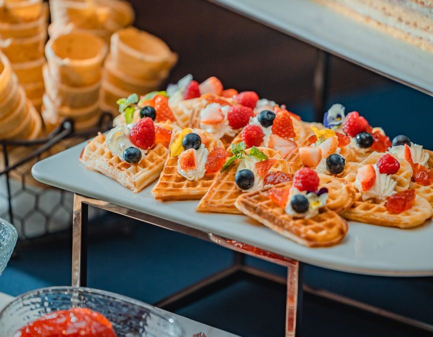 5 Hotel Breakfast Rules Families Should Check Before Leaving the Room 4 A vibrant display of waffles topped with fresh berries and cream, perfect for a delightful breakfast.