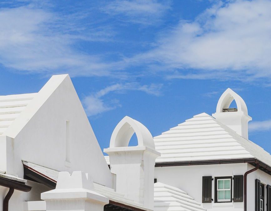 Elegant whitewashed buildings with unique architecture in Rosemary Beach, FL under a clear blue sky.