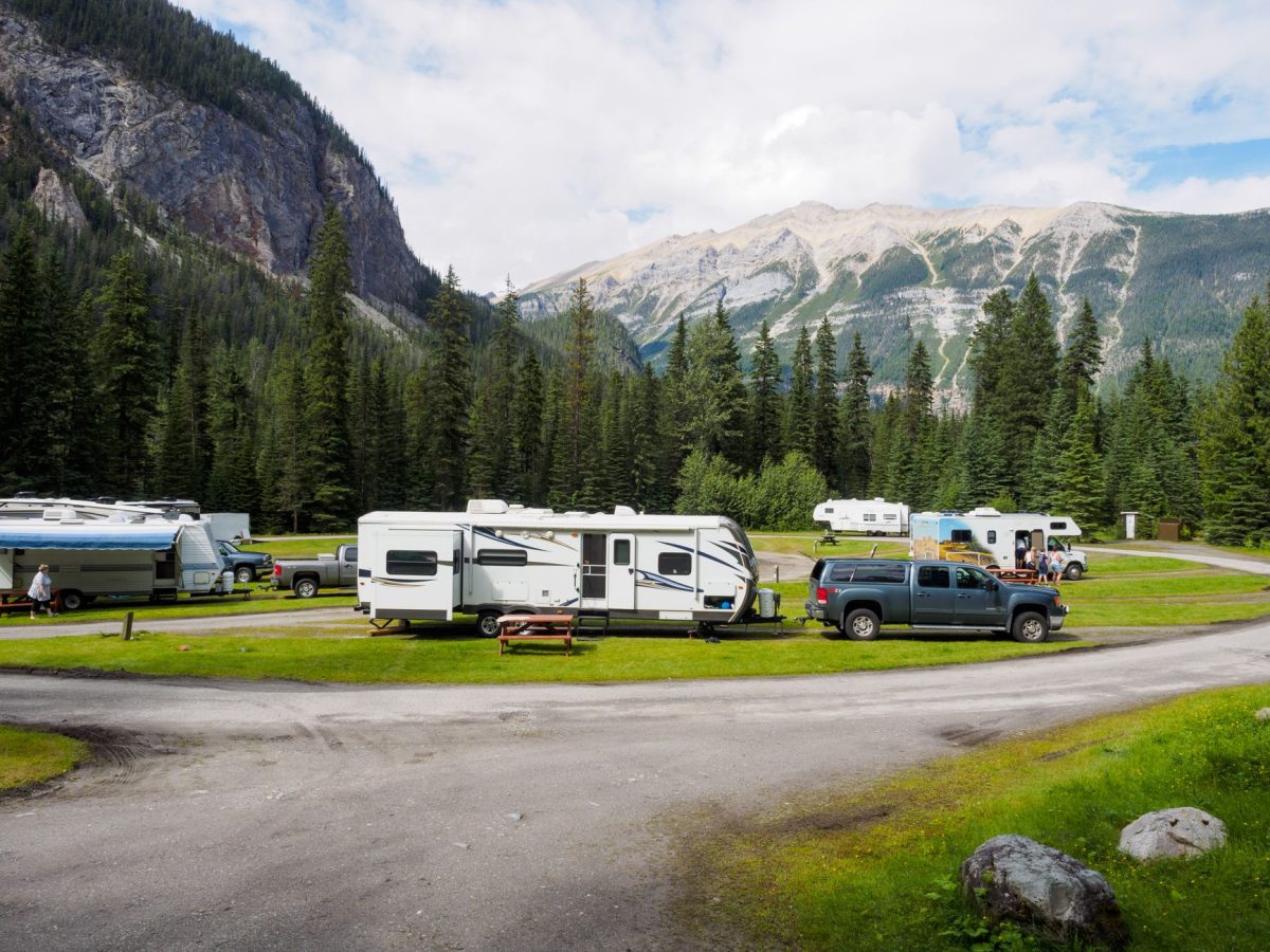 5 Campground First-Night Checks Travelers Usually Wish They Did Before Dark 3 A beautiful campsite featuring RVs amidst lush forests and towering mountains for a peaceful getaway.