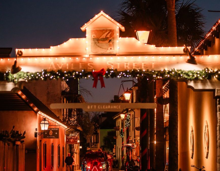 Beautifully lit street in St. Augustine with Christmas decorations creating a warm festive atmosphere at night.