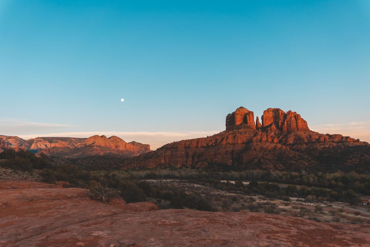 Beautiful view of Sedona&amp;amp;#39;s iconic red rocks with a full moon at sunset.