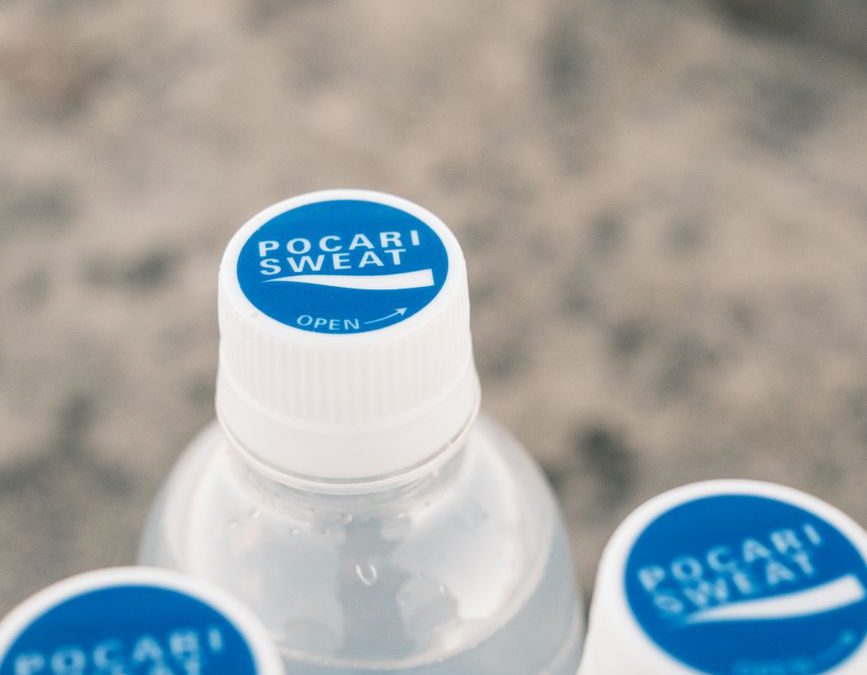 5 Airport Food Habits Frequent Flyers Use to Avoid Regret 2 Three Pocari Sweat bottles on sandy background, creating a refreshing summer feel.