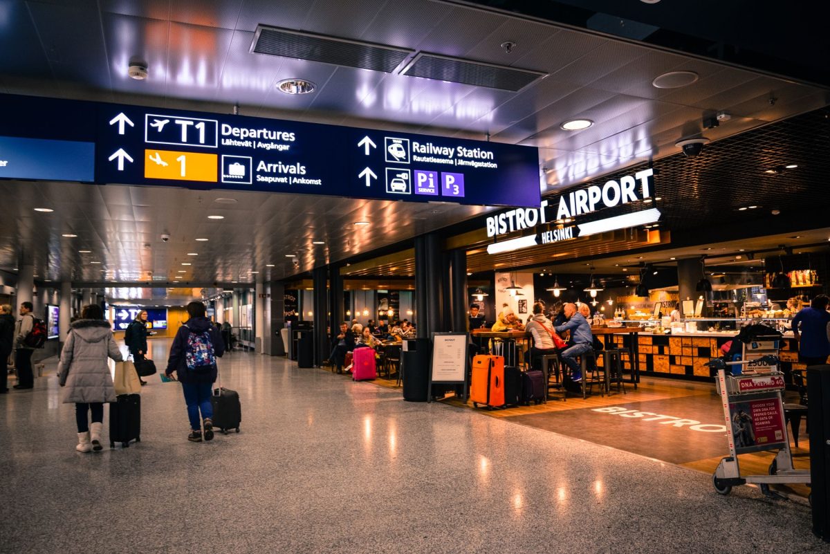 5 Airport Food Habits Frequent Flyers Use to Avoid Regret 4 Travelers at Helsinki Airport dining and shopping near departures and arrivals.