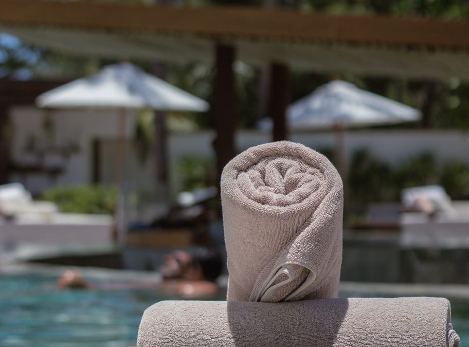 Tropical poolside ambiance with sunshades and fresh towels ready for a perfect summer day.