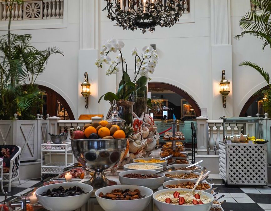 Elegant hotel dining hall featuring a diverse buffet with luxurious decor and chandeliers.