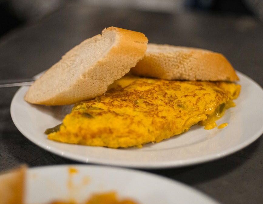 A flavorful Spanish omelette served with slices of bread, typical tapas in Madrid.