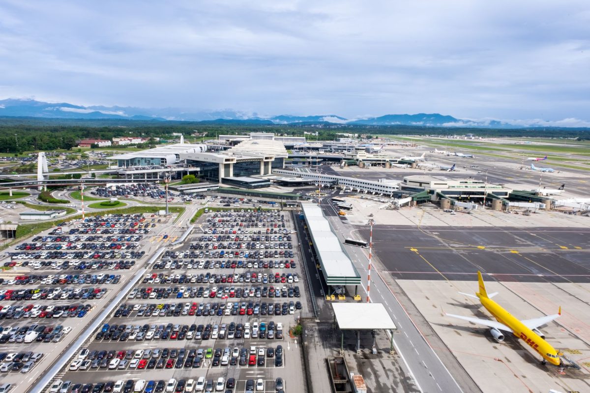 Dynamic aerial perspective of Milano Malpensa Airport showcasing terminal activity and bustling airplane operations.