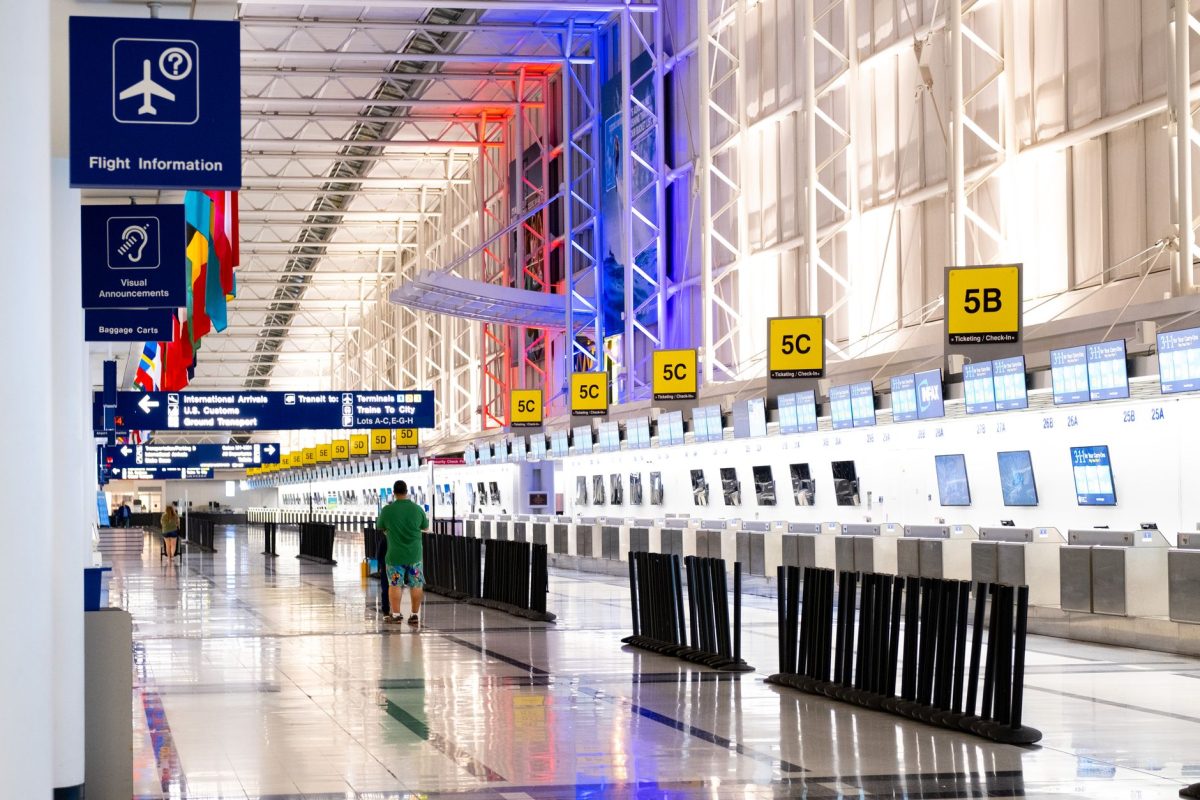 Wide view of Chicago airport terminal showcasing architecture and check in counters. Flags and signages add vibrant detail.