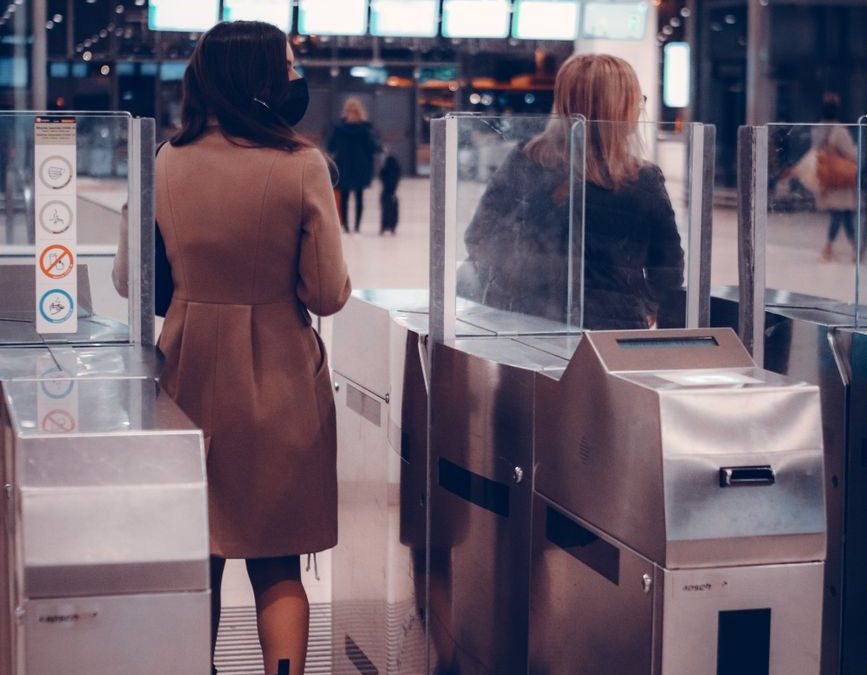 Two women passing through airport security gates, highlighting modern travel.