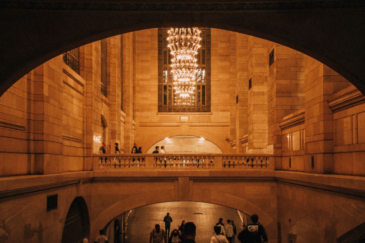 Warmly lit interior of Grand Central Terminal showcasing beautiful chandeliers and stone architecture.