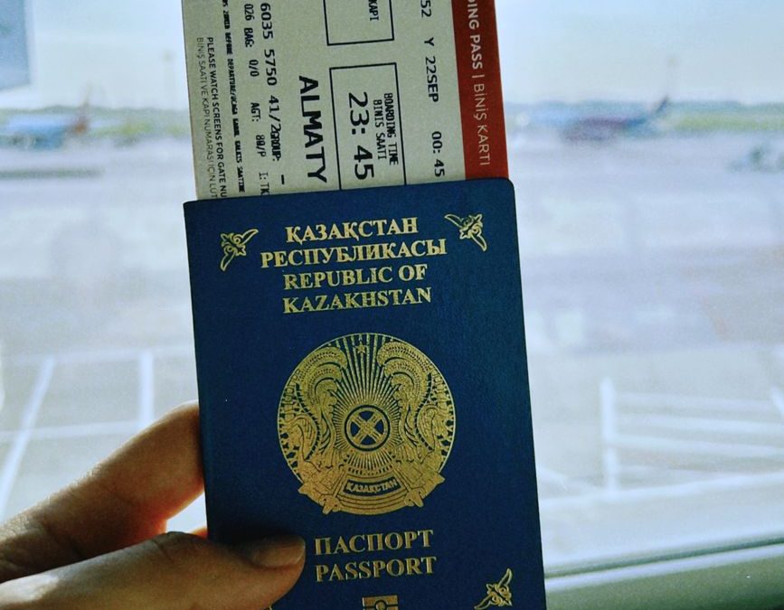 Kazakhstan passport with boarding pass in Warsaw airport, ready for travel.