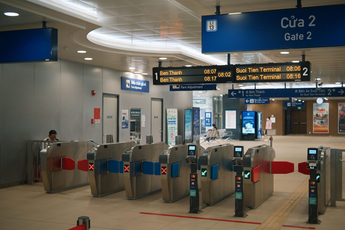 Metro station entrance with ticket barriers and digital signs, capturing urban transport.