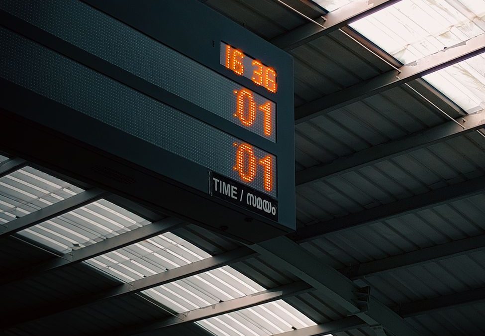Digital clock display at Kochi railway station showing time and platform information.